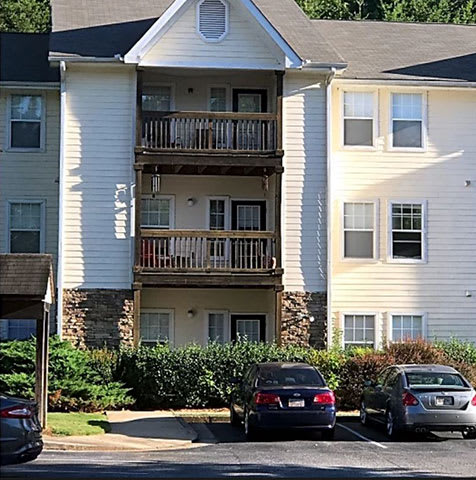 an apartment building with cars parked in front of it