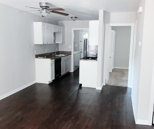 a kitchen with white cabinets and black appliances