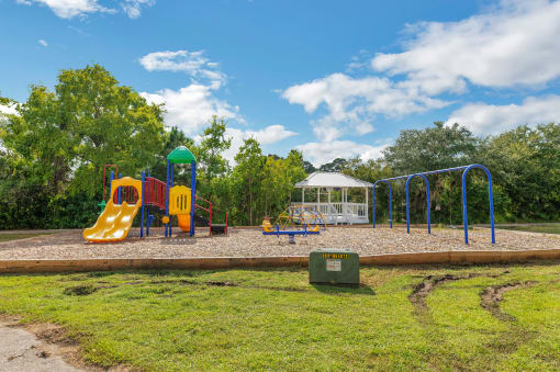 a playground with a swing set and a gazebo