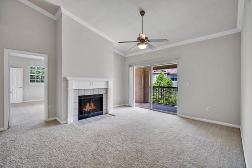 an empty living room with a fireplace and a ceiling fan