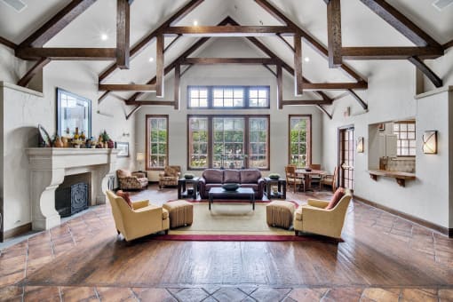 the living room has a large fireplace and a ceiling with exposed beams
