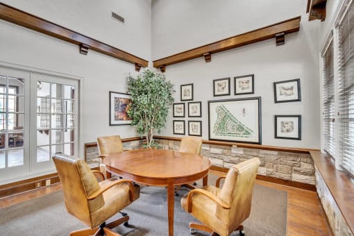 a dining room with a table and chairs and pictures on the wall