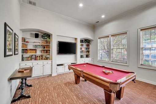 a game room with a pool table and a tv