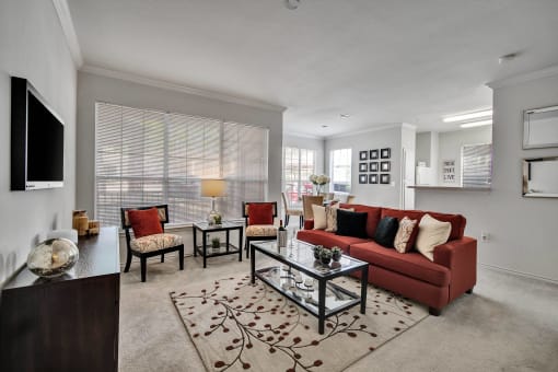 a living room with a red couch and a glass coffee table
