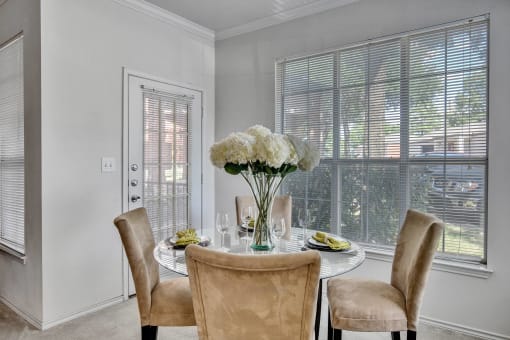 a dining room with a table and chairs and a window