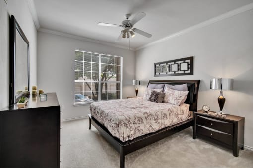 a bedroom with a bed and a ceiling fan