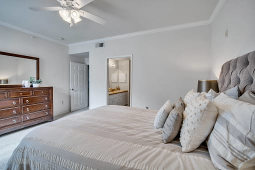 a master bedroom with a large bed and a dresser