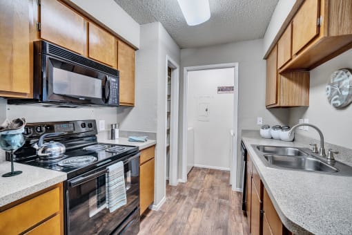 a kitchen with a sink and a stove and a microwave