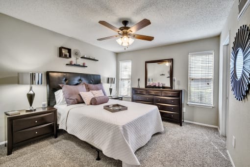 a bedroom with a bed and a ceiling fan