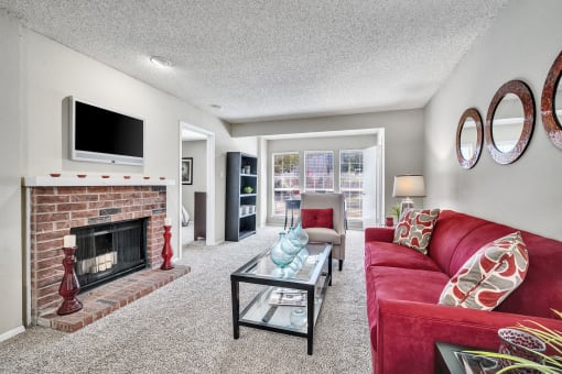 a living room with a red couch and a fireplace