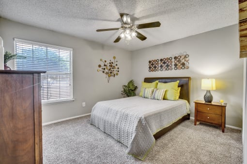 a bedroom with a bed and a ceiling fan