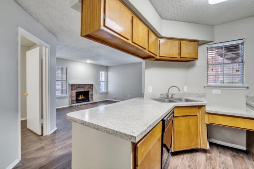a kitchen with an island and a living room with a fireplace