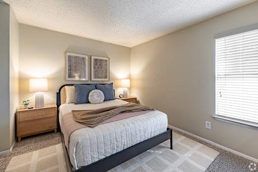 Bedroom with neutral decor and large window at Highland Park Apartments, Fort Worth, TX