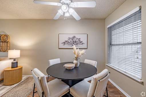 Dining room with round table and upholstered chairs at Highland Park Apartments, Fort Worth, Texas