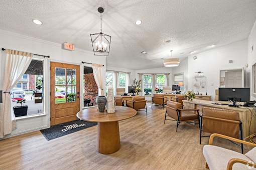 A well-lit waiting room with a wooden floor and a variety of seating options.
