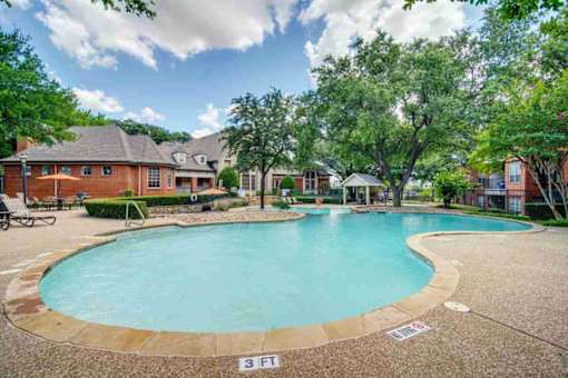 a large swimming pool with a house in the background
