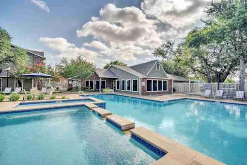 a large swimming pool with a house in the background