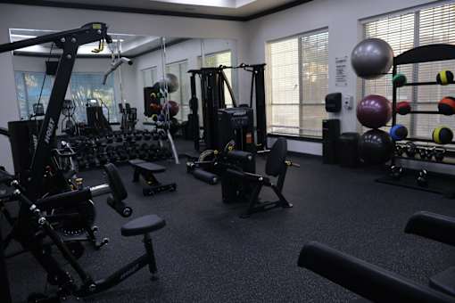 Fitness center with strength training equipment and weights at Clearwater Creek Apartments, Richardson, Texas