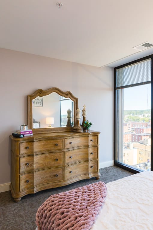 a bedroom with a dresser and mirror