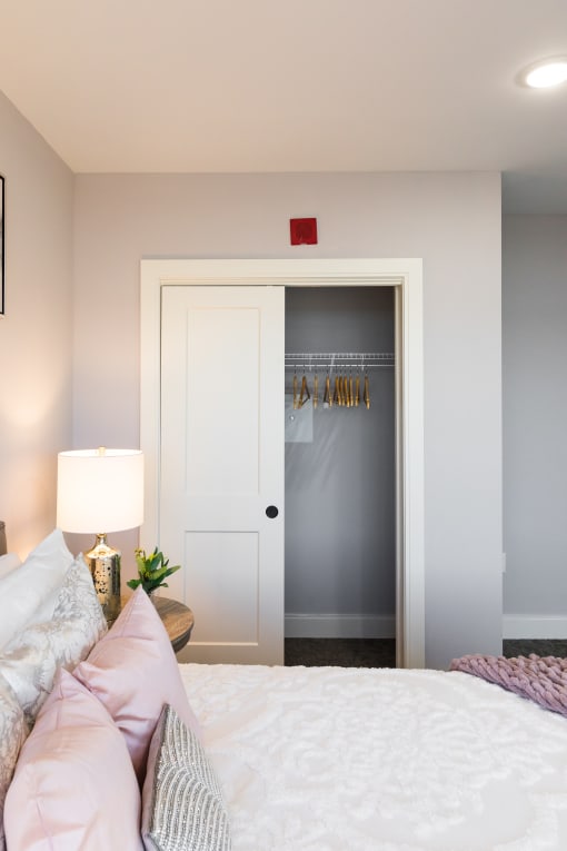a bedroom with a bed and a closet with a door open