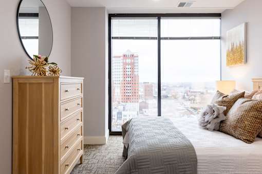 A bedroom with a large bed and a view of the city.