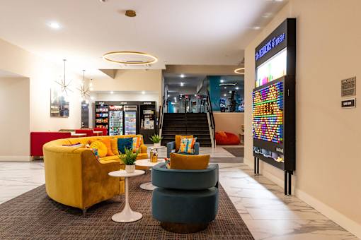 the lobby of a hotel with couches and chairs and a vending machine