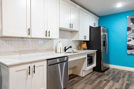 a kitchen with white cabinets and a stainless steel refrigerator