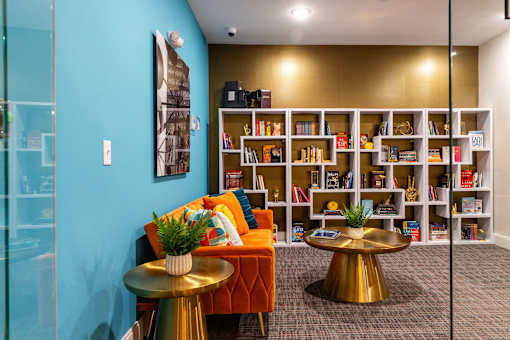 a living room with a couch and tables and a bookshelf