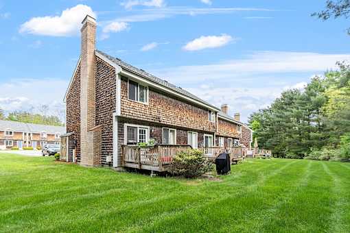 A brick house with a chimney and a porch.