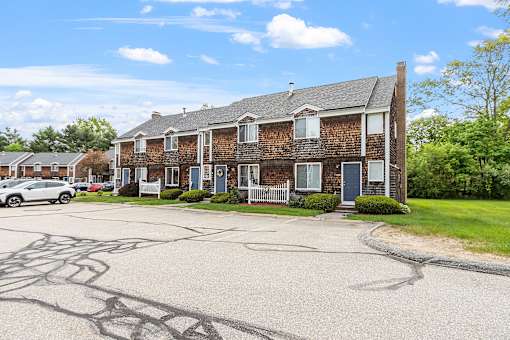 A large brick house with a driveway in front.