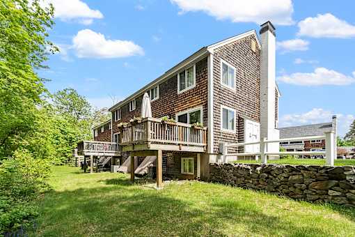 A house with a stone wall in front.