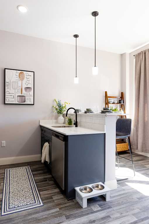 A kitchen with a sink and a fridge.