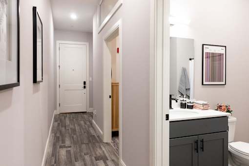 A bathroom with a toilet, sink, and mirror.