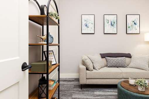 A living room with a couch, a coffee table, and a bookshelf.