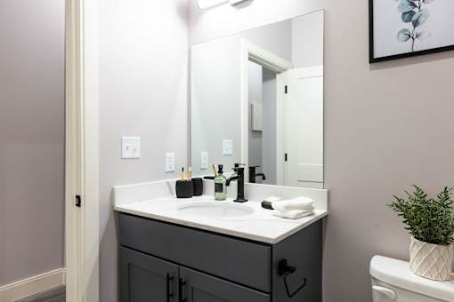 A bathroom with a sink, mirror, and toilet.