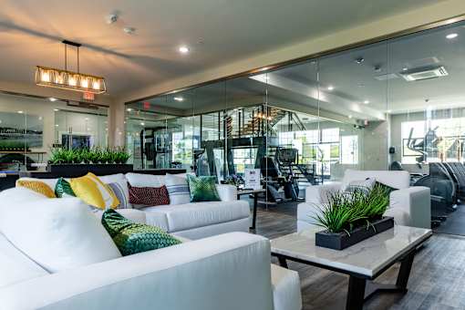A modern living room with a white sofa and a glass wall.
