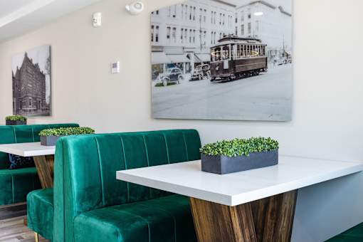 A white table with a green couch and a plant on it.