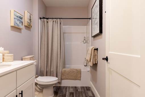 A bathroom with a toilet, sink, and shower.