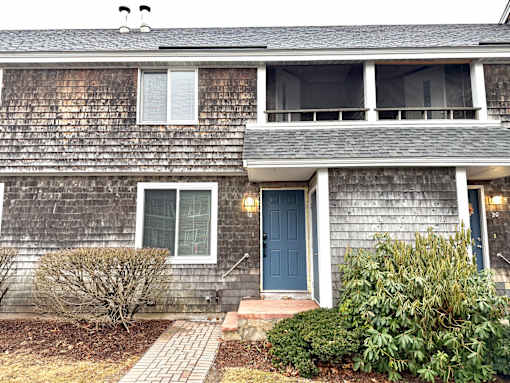 A house with a grey siding and a blue door.