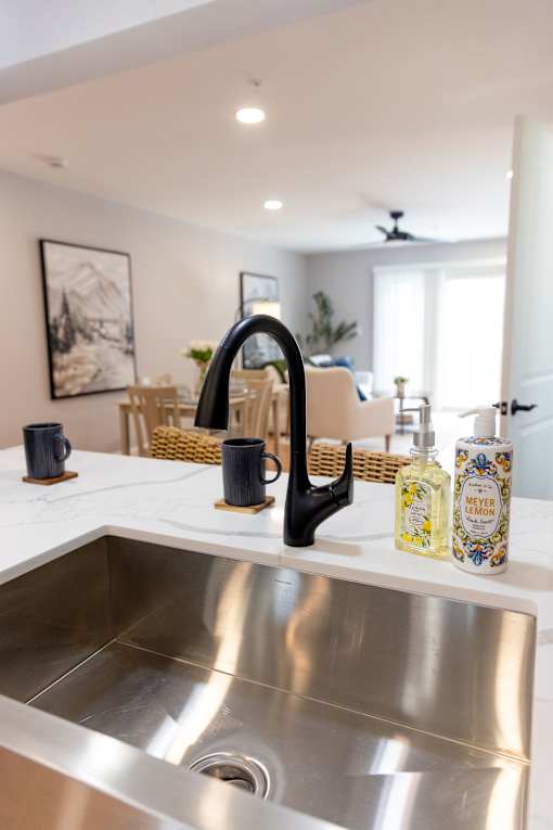 A modern kitchen with a stainless steel sink and a black faucet.