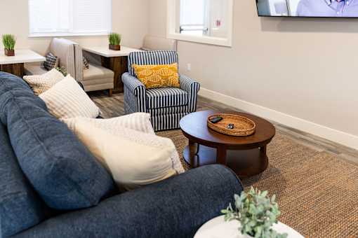 A living room with a blue couch and a wooden coffee table.