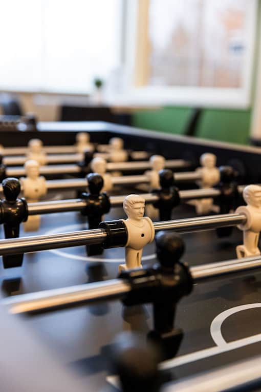 A close up of a foosball table with black and white players.