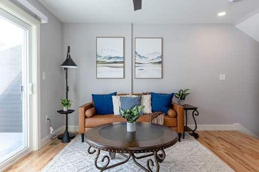 A living room with a couch, a table, and two pictures on the wall.