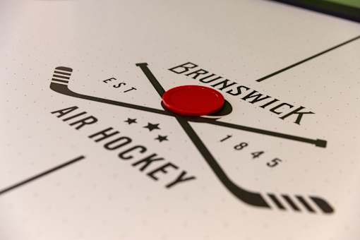 A close up of a clock with the words "Brunswick Air Hockey" and "Est. 1845" on it.