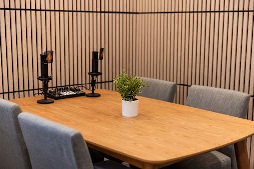 A conference table with chairs and a plant on top.
