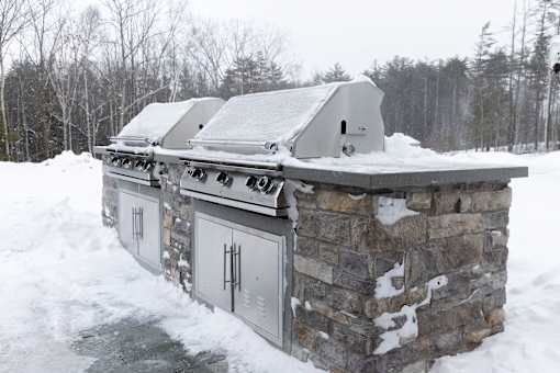 A stone building with a metal roof covered in snow.