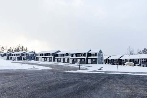 A row of houses with a snowy landscape in the foreground.