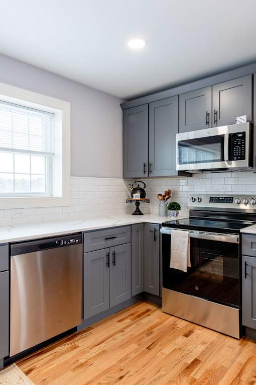 A kitchen with a stainless steel dishwasher and oven.
