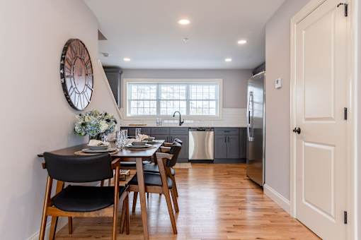 A modern kitchen with a dining table set for two.