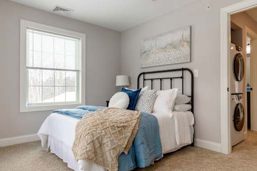 A bedroom with a bed, pillows, and a blanket.